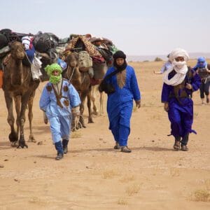 camels and people walking through the desert