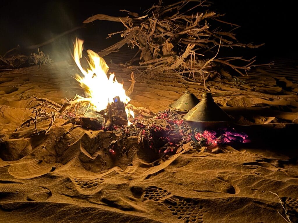 fire on the sand and tagines being cooked
