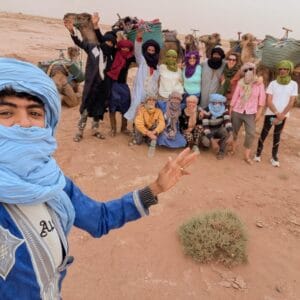 group of people and camels in the desert