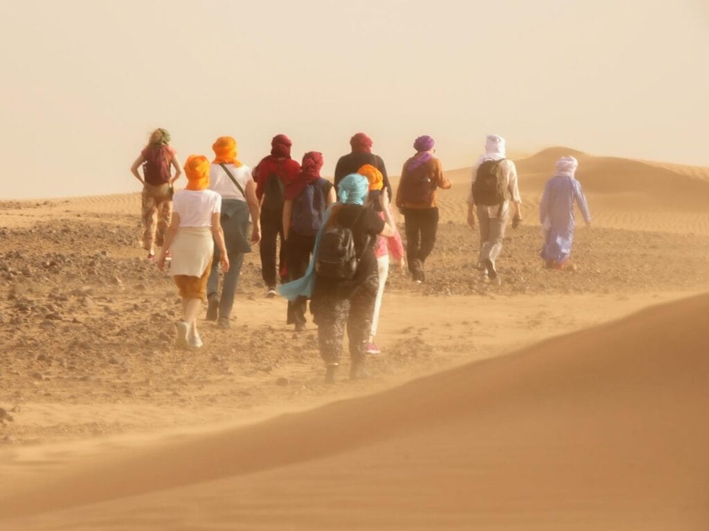 group of people walking in the desert